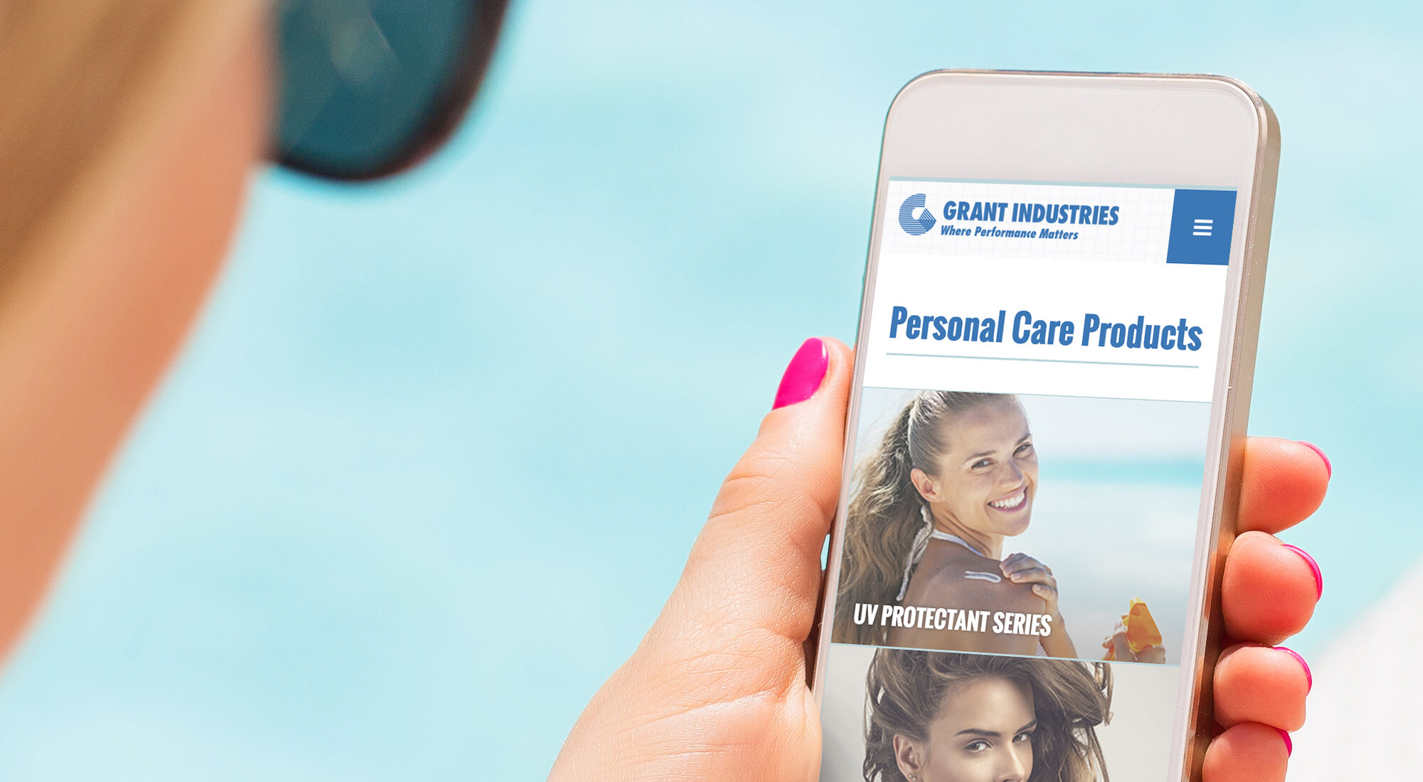Person holding a smartphone displaying a website for personal care products by Grant Industries, with an image of a smiling woman in the background.