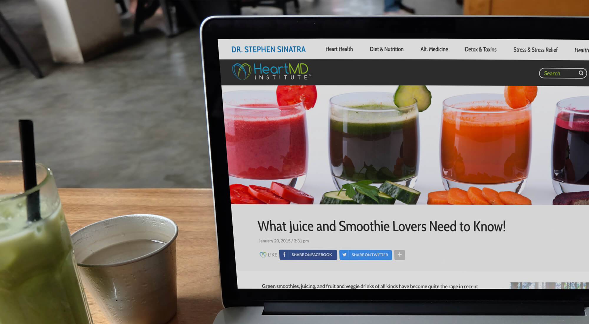 A laptop displays a webpage titled "What Juice and Smoothie Lovers Need to Know!" featuring three glasses of colorful juices or smoothies with fruit and vegetable garnishes.