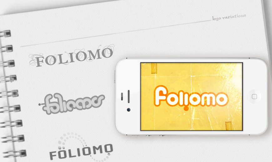A notebook with different "Foliomo" logo designs is shown next to a white smartphone displaying a colorful "Foliomo" logo on its screen.