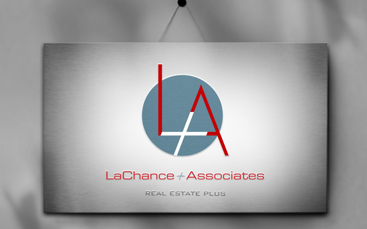 A metallic sign displays the LaChance + Associates logo, featuring large red initials “LA” over a blue circle, with "Real Estate Plus" written below.