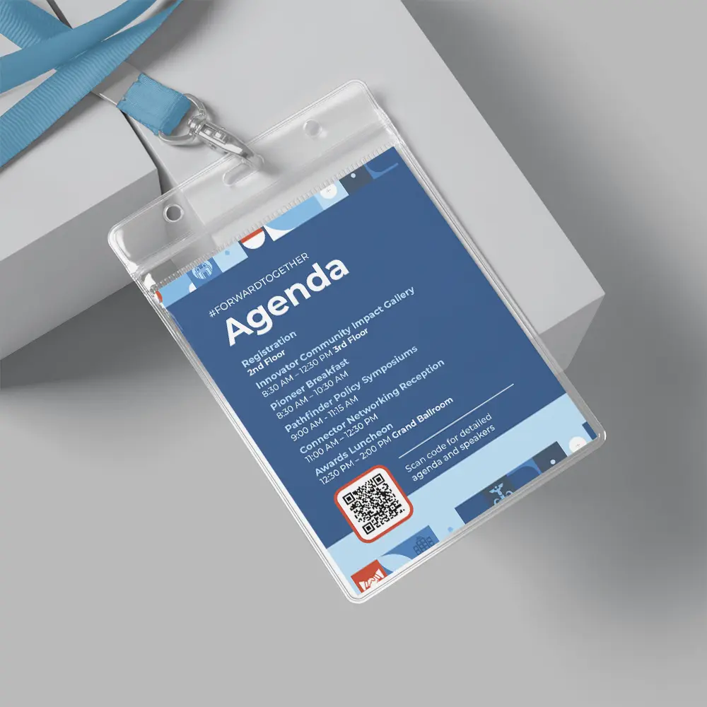 A blue conference badge from a Small Business Branding Agency with a lanyard displays an agenda, event details, and a QR code on a gray surface.