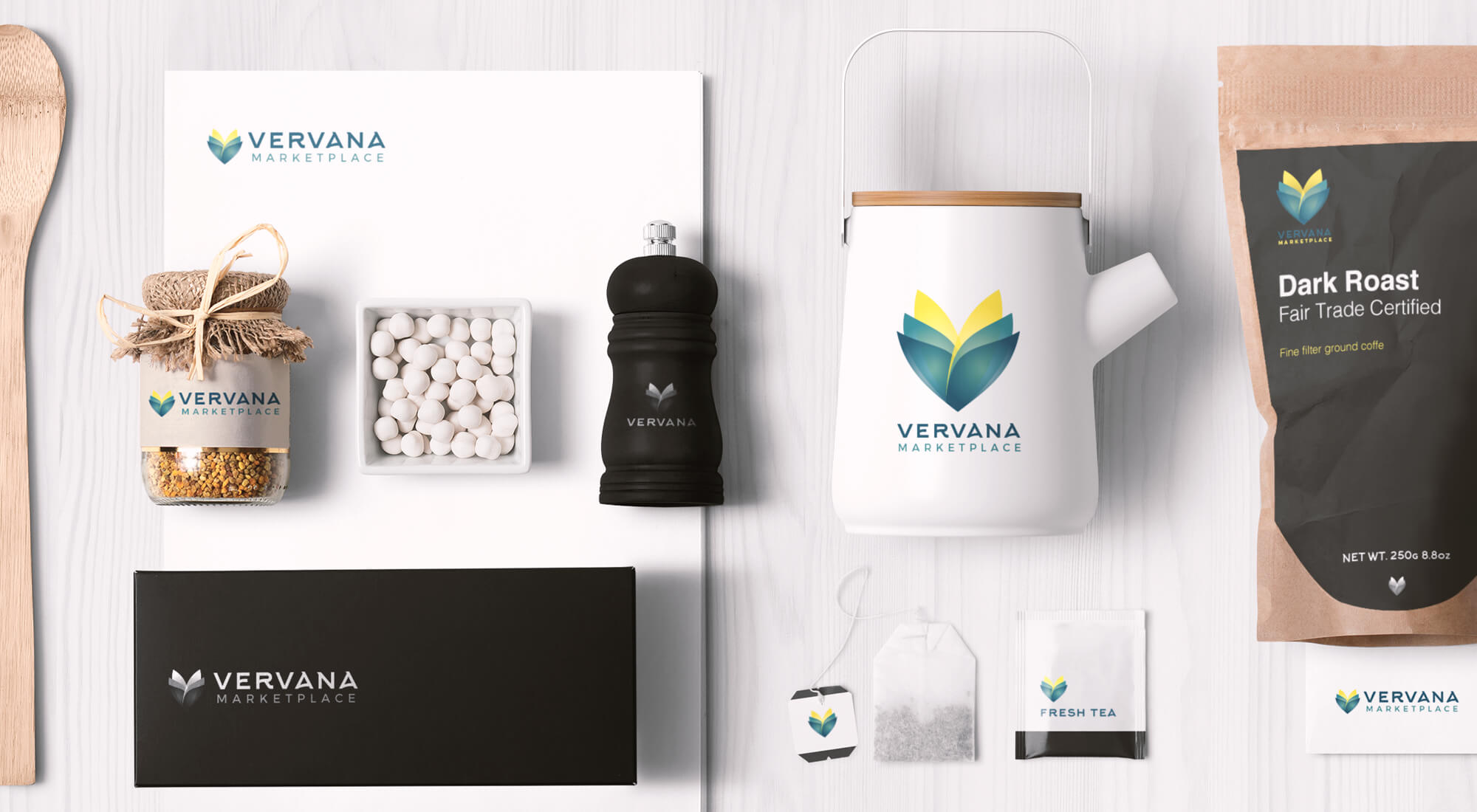 Various branded Vervana Marketplace products, including a kettle, tea bags, pepper grinder, packaging, and stationery, are neatly arranged on a white surface.