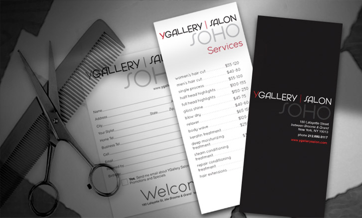 Three YGallery Salon SOHO brochures are displayed on a surface with a pair of hair-cutting scissors and a comb in the background.