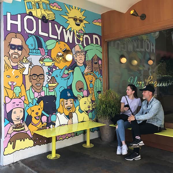 couple sitting on bench looking at wall-art