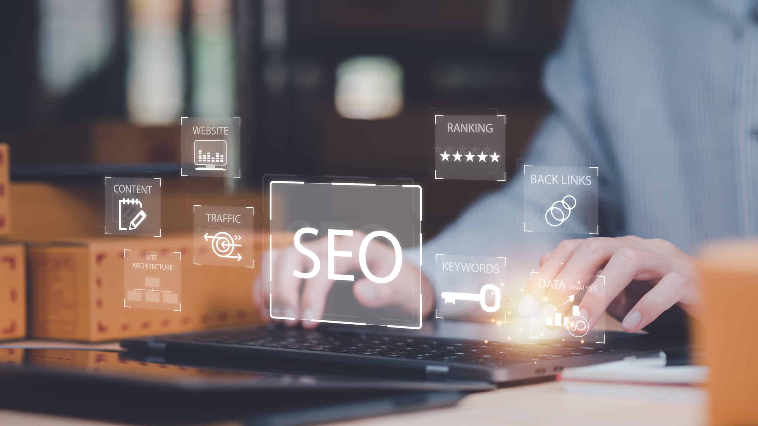 Person typing on a laptop with floating digital icons representing Website Redesign SEO concepts such as keywords, traffic, ranking, website, and backlinks.